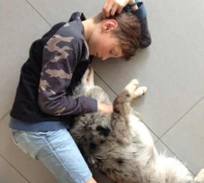 a boy lies on the tile with his dog